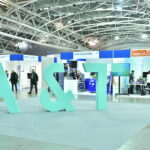Area espositiva della Fiera A&T all'Oval Lingotto con stand di aziende specializzate in automazione e testing.